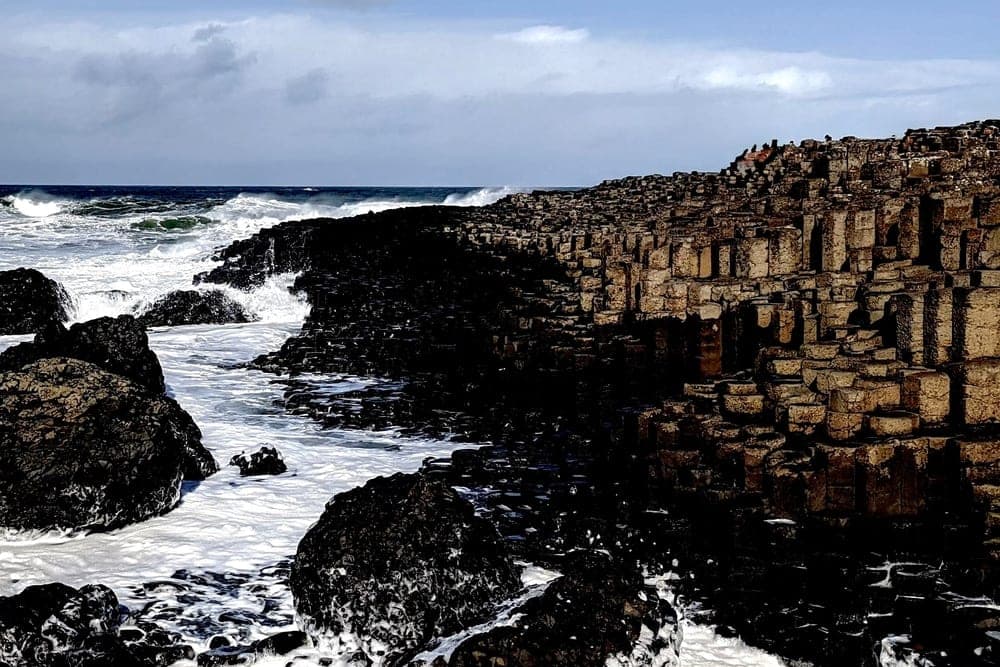 The hexagonal basalt columns of the Giant's Causeway, United Kingdom, meet the crashing waves of the Atlantic Ocean.