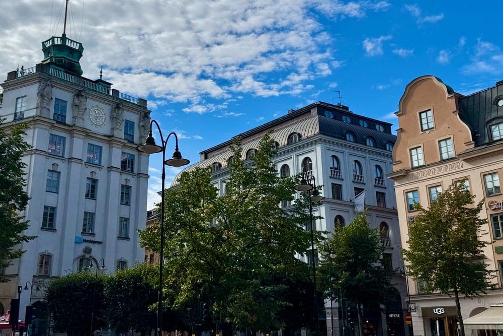 Buildings in Stockholm, Sweden, under a bright, cloudy blue sky.