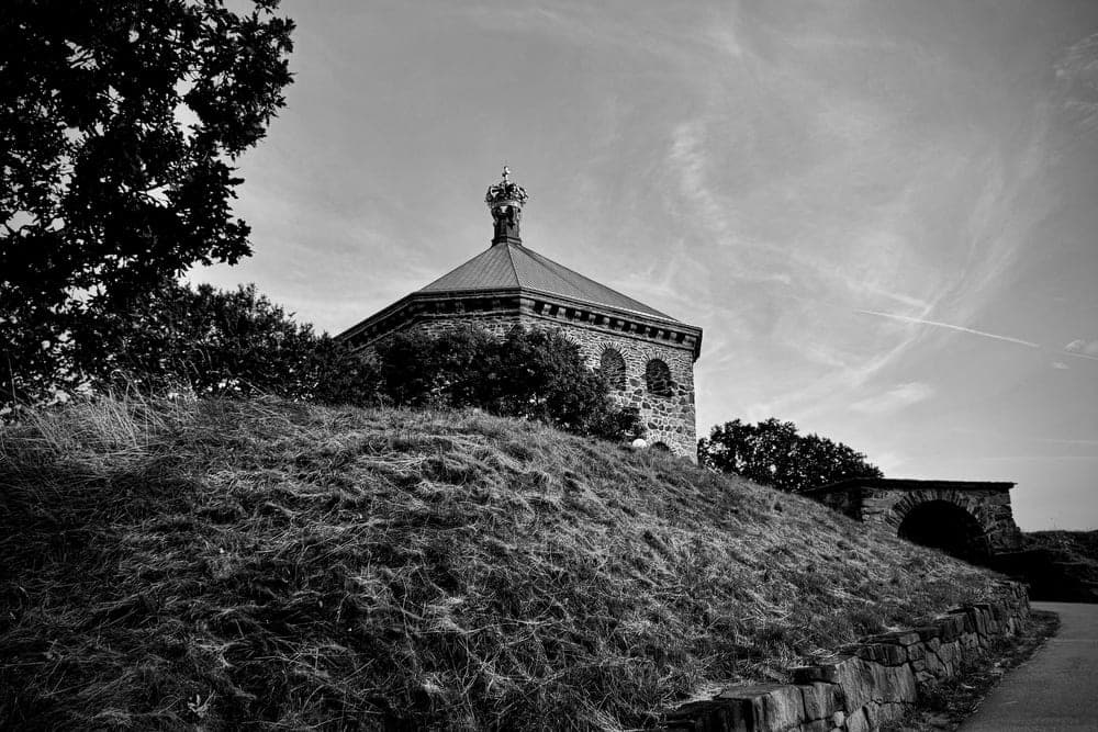 The Skansen Kronan fortress with a crown-topped spire, seen from a grassy hill in Göteborg, Sweden.