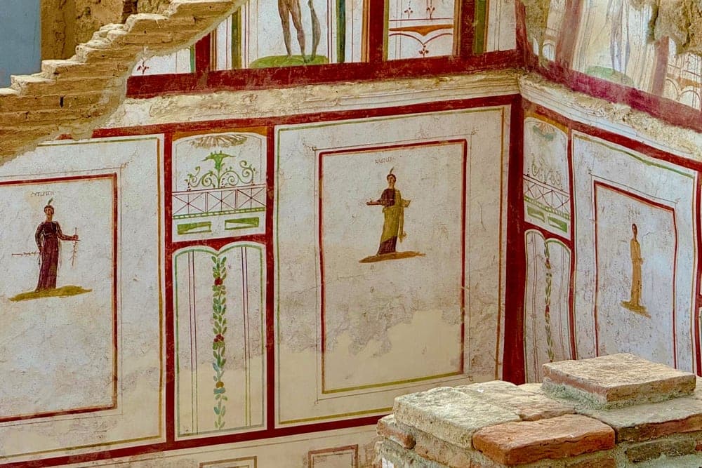 Frescoed walls inside an ancient building in Acarlar, Selçuk, İzmir, Türkiye, depicting figures and decorative patterns.