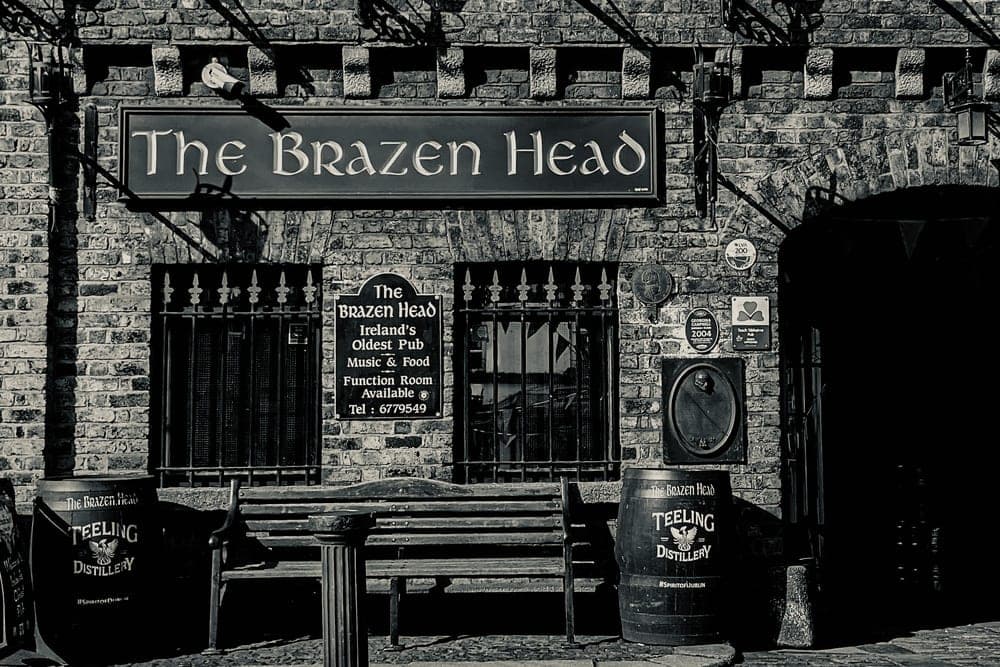 The Brazen Head, Ireland's oldest pub, in Dublin, Republic of Ireland, with a bench and Teeling Distillery barrels.
