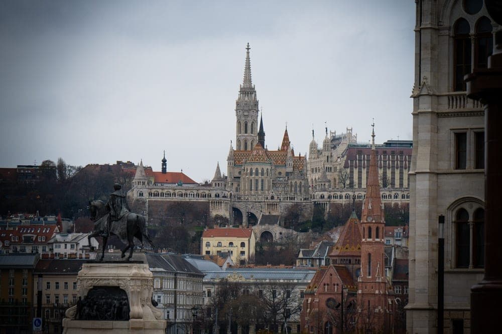 Equestrian statue in the foreground with Matthias Church and Fisherman's Bastion in the background, Budapest, Hungary.