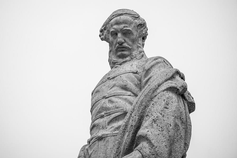 A black and white photo of a stone statue of a man in Budapest, Hungary.