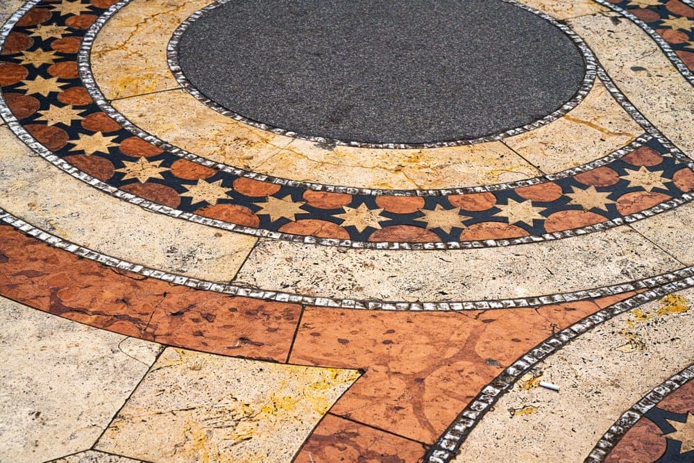 Close-up of a decorative mosaic floor pattern with stars and geometric circles in Budapest, Hungary.