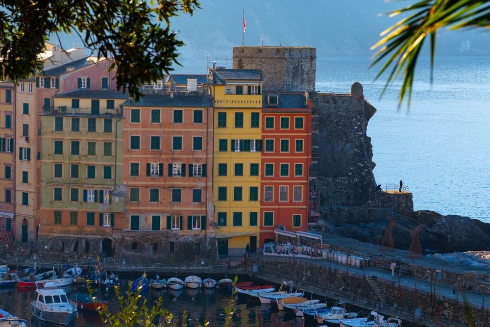 Colorful buildings on the waterfront of Camogli, Genoa, Italy, with a harbor full of boats.