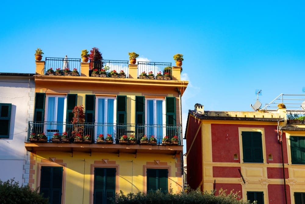 Colourful balconies with flowers on buildings in Portofino, Italy.