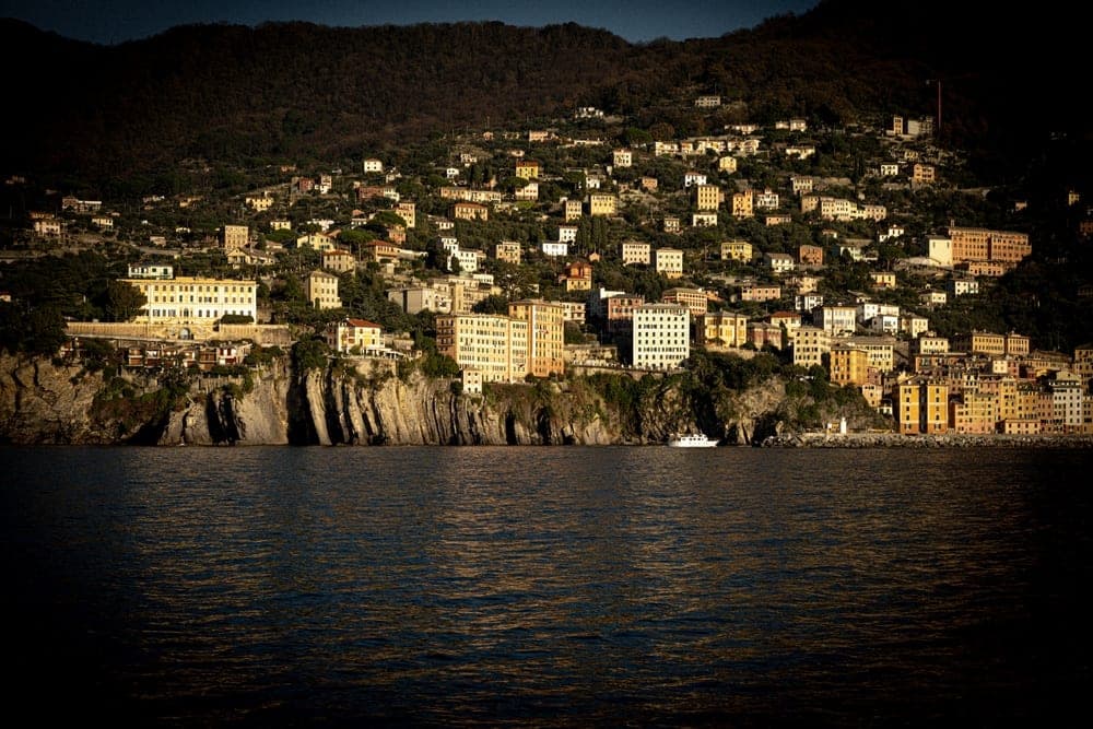 The colourful hillside town of Camogli, Genoa, Italy, overlooking the dark blue Ligurian Sea.