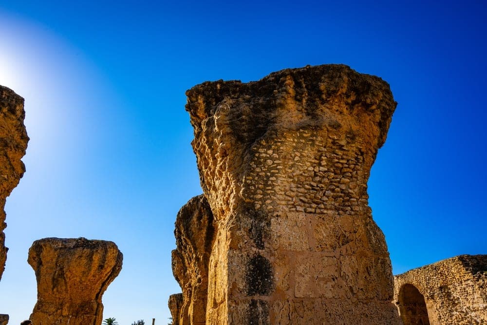 Ancient stone ruins of Carthage in Tunis, Tunisia, under a bright blue sky.