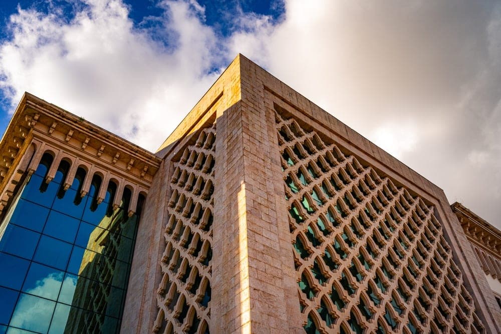Geometric stone facade and blue glass reflections of a building in Tunis, Tunisia.